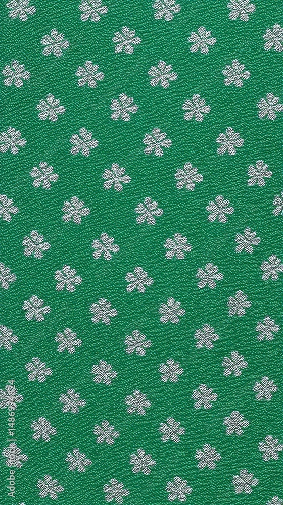 Poster repeating clover-shaped pattern on a green background.