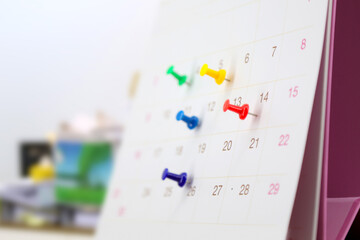 Desk calendar with pins for reminder in office workplace concept of time management agenda event planner or personal organization for business meeting and schedule planning or holiday plan.