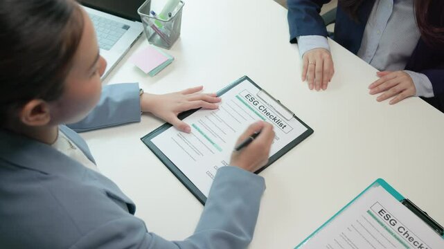 Asian female audit ESG risk check list paper form net zero waste supply chain vendor eco go green carbon credit control. Asia people woman give advice report prepare work review best practice process.