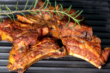Chargrilled Pork Ribs on Black Grill with Fresh Rosemary – High Contrast Barbecue Scene