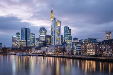 Obraz premium Cityscape with modern skyscrapers and river reflection.