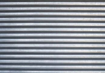 Metallic roller shutter with horizontal grooves.
