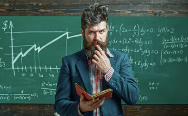 Teacher explains math in class. Professor in classroom on math lesson. School teacher writes math...
