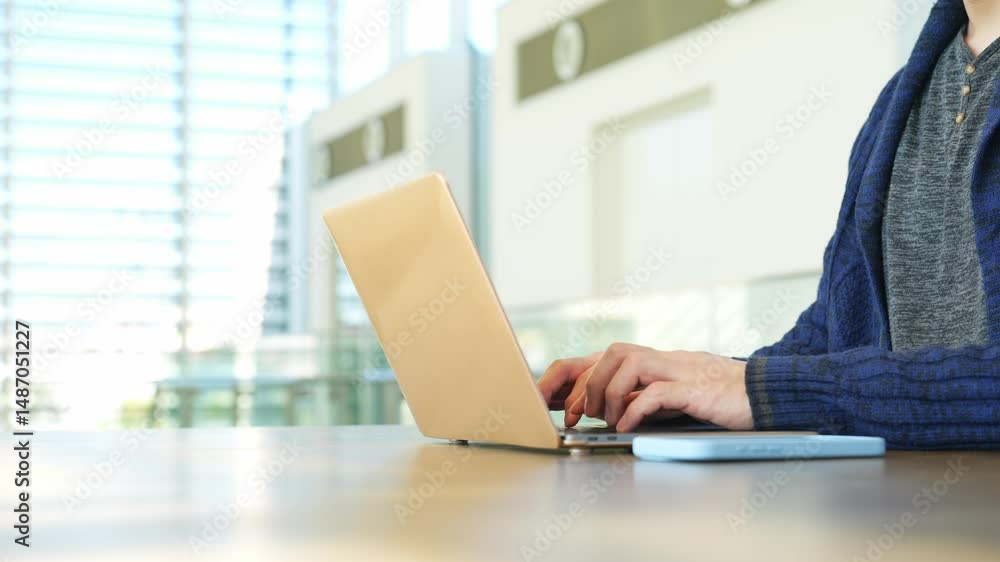 Poster man using laptop in lobby