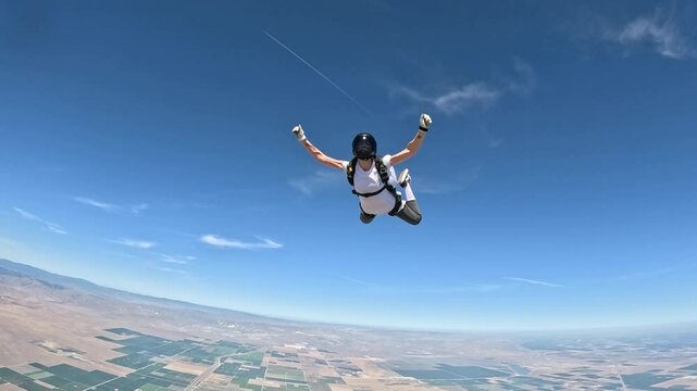 A skydiver is falling in the blue sky,