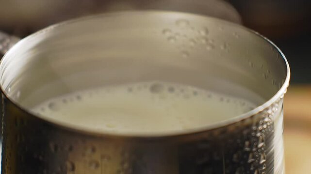pouring milk into a glass, Steaming Milk in a Stainless Milk Jug
