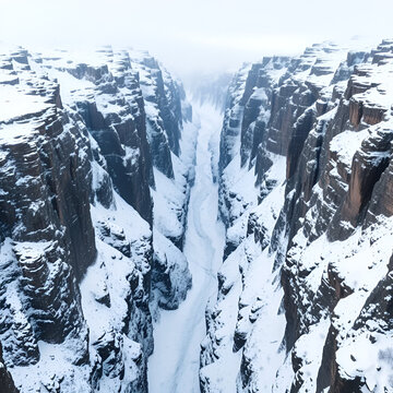 breathtaking snowy gorge surrounded by towering rocky cliffs, creating serene and majestic winter landscape. icy terrain and steep walls evoke sense of adventure and tranquility
