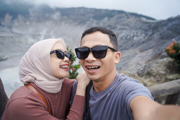 Happy Asian Couple Taking a Selfie at Volcanic Crater