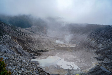 Steaming Volcanic Crater with Sulfur Pools and Dense Fog in Mountain Landscape. Tangkuban Perahu