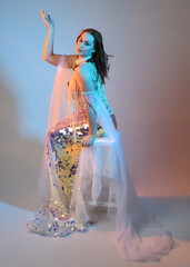Fantasy studio portrait of a red-haired mermaid faery model wearing a white pearl gown, fairytale...