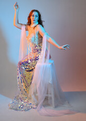 Fantasy studio portrait of a red-haired mermaid faery model wearing a white pearl gown, fairytale...