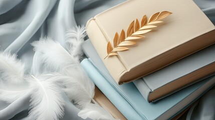 Stacked books adorned with feathers and a gold leaf.