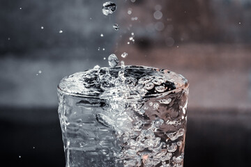 Water Splashing into Glass on Dark Background