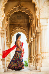 Young female tourist dancing between arches and Pillars.