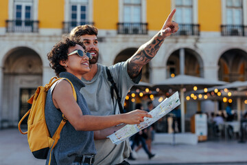 Tourists holding map and pointing in lisbon, portugal