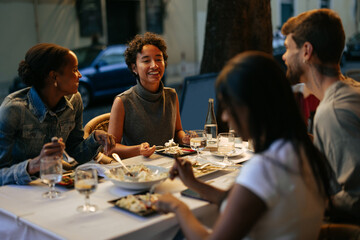 Friends enjoying dinner together at outdoor restaurant