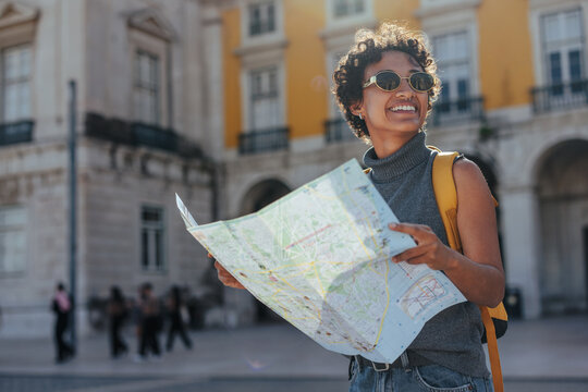 Tourist exploring lisbon with map and backpack, enjoying summer vacations in portugal