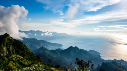 Obraz premium Vast Mountain Landscape Under Blue Cloudy Sky with Sunlight on Horizon