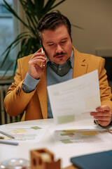 Man looking at papers and talking on the phone