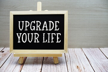 Upgrade Your Life text written on chalkboard with easel on wooden background