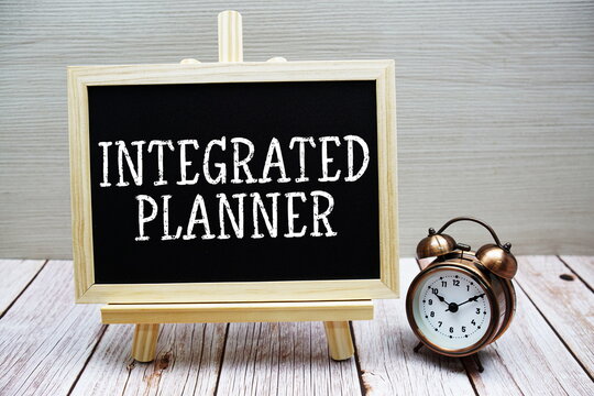 Integrated Planner text written on chalkboard with alarm clock on wooden background