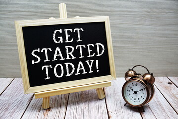 Get Started Today! text written on chalkboard with alarm clock on wooden background