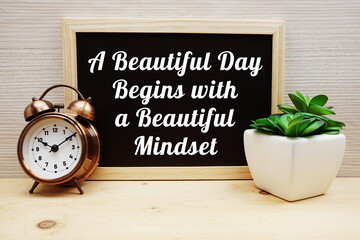 A Beautiful Day Begins With A Beautiful Mindset Motivational And Inspiration Quotes with alarm clock on wooden background
