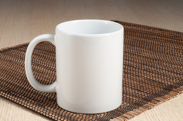 Two-tone 11oz mug on the straw mat on the table. Mug with black handle and inner part. Applicable for mockup