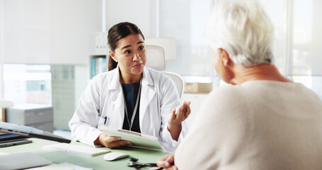 Obraz premium Senior woman, doctor and talking to patient for healthcare report, symptoms or checkup. Medical professional, appointment or consultation for help with checklist for insurance application in hospital