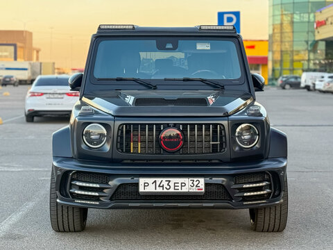 Black Mansory Mercedes Benz G63 AMG parked in the city street. Black Mercedes-Benz W500 G-class in the parking. Gel&auml;ndewagen. Brabus G Wagon. Mansory G-Wagon. 