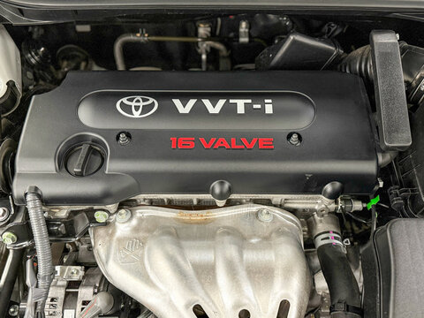 Close up the engine bay on a Toyota Camry Head cover on the block with the Toyota logo and VVT-i technology. The engine room of all Toyota Camry showing the VVT-I engine.
