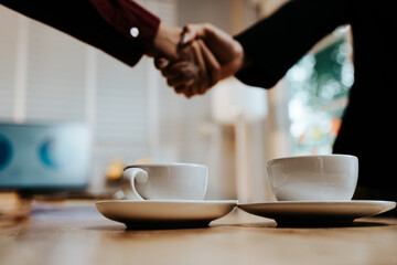Young adults enjoy coffee and conversation at a cozy café, sharing laughter, bonding, and relaxation in a warm, friendly atmosphere indoors.