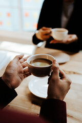 Young adults enjoy coffee and conversation at a cozy café, sharing laughter, bonding, and relaxation in a warm, friendly atmosphere indoors.