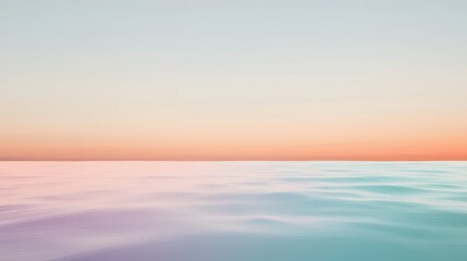 Obraz premium Vast serene ocean landscape with calm water reflecting pastel sunset colors and clear sky, perfect for tranquility and nature backgrounds in design projects.