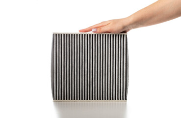 Modern carbon filter in hand for air purification in car interior on white background, isolate, close-up