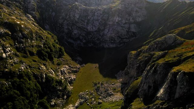 Aerial Tilt Up Shot Of Green Landscape Amidst Rock Formations Against Clear Sky On Sunny Day - Plav, Montenegro