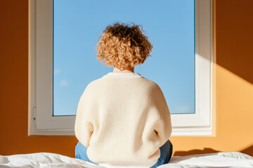 A teenage girl sitting on her bed