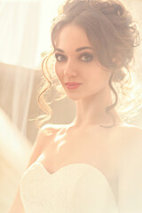 Close-up portrait of a luxurious bride in a wedding dress in the morning in a chic interior. wedding makeup and hairstyle. Beautiful face with big green eyes