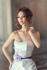 Close-up portrait of a luxurious bride in a wedding dress in the morning in a chic interior. wedding makeup and hairstyle. Beautiful face with big green eyes