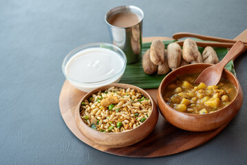 A wooden tray with three bowls of food on it, including a bowl of rice