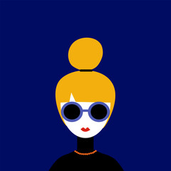Portrait of woman with a blonde bun and sunglasses.