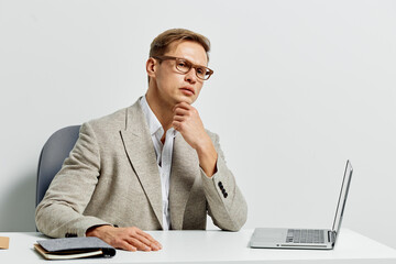 thoughtful man working digital nomad remote laptop business casual eyeglasses indoor studio...