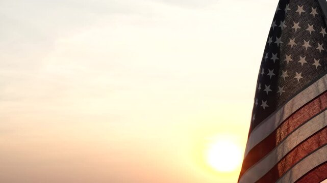 Fourth of July. Silhouettes of American flag waving on background of beautiful sunset or sunrise for honoring, mourning USA military. 4th of July, Memorial Day, Happy Holiday American Concept