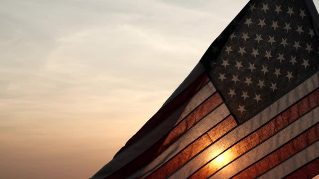 4th Of July. Silhouettes of American flag waving on background of beautiful sunset or sunrise for honoring, mourning USA military. Fourth of July, Memorial Day, Happy Holiday American Concept