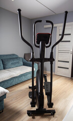 Modern Elliptical Trainer in the Room at Home. Concept of Exercising at Home, fitness