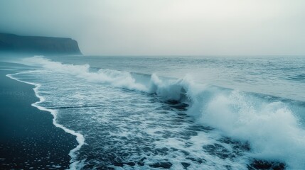 Fototapeta premium Moody Seascape Dramatic Waves Crashing on Dark Sand Beach under Foggy Sky