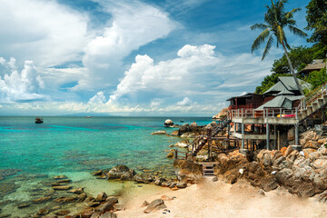 Summer vacation landscape of a bay and clear blue beach with rocks and corals on Koh Tao.