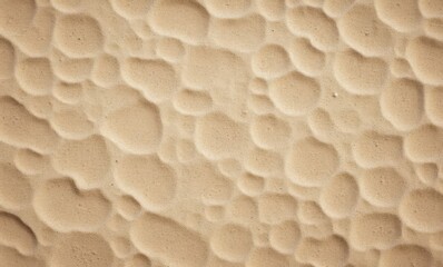 Textured surface with soft, rounded shapes in warm beige tones.