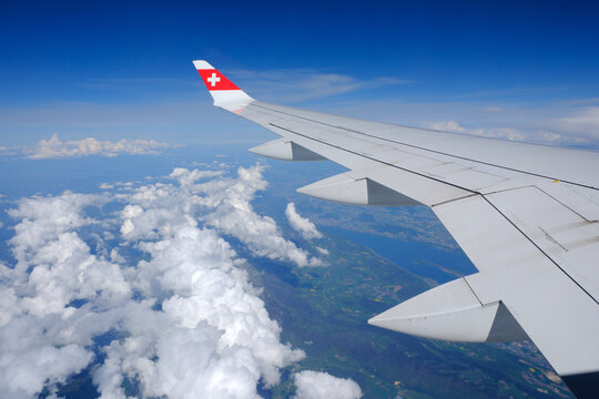 Swiss Airlines Airbus A220 wing and cumulus clouds