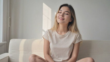 Obraz premium Serene Moment: A Young Woman Enjoys a Quiet Moment of Contemplation as the sunlight gently illuminates her face.